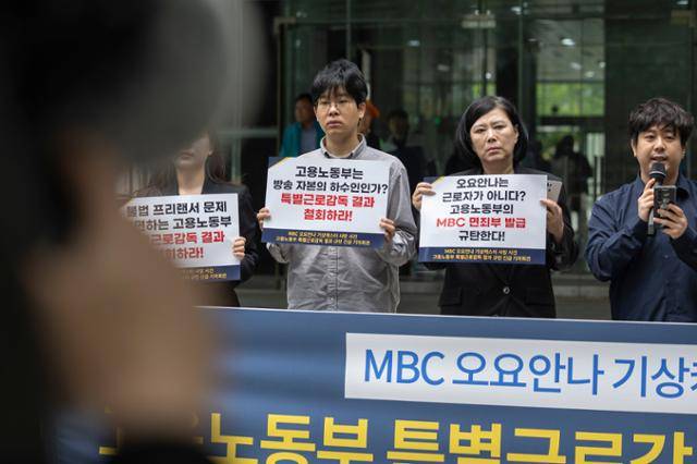 19일 서울 중구 서울고용노동청 앞에서 열린 MBC 기상캐스터 고(故) 오요안나씨 특별감독 결과 규탄 기자회견에서 오씨의 어머니 장연미씨와 참석자들이 손팻말을 들고 있다. 연합뉴스
