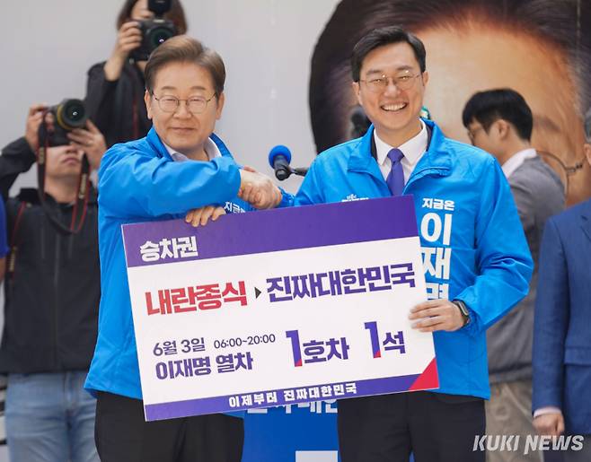 이재명 더불어민주당 대선 후보가 19일 서울 용산역광장에서 열린 집중 유세에서 장경태 의원으로부터 이재명 열차 승차권을 전달받은 후 기념 촬영하고 있다. 유희태 기자