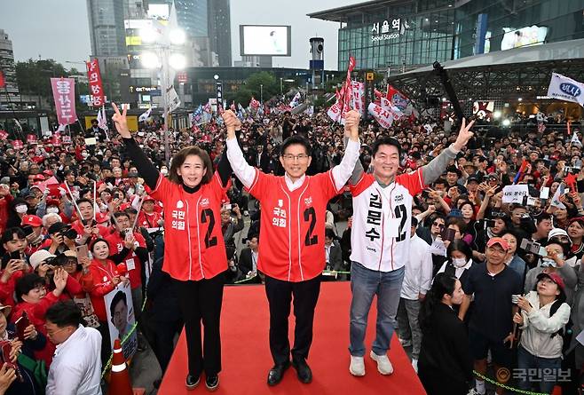 김문수 국민의힘 대선 후보가 19일 서울역 광장에서 열린 유세에서 공동선거대책위원장인 나경원, 안철수 의원과 함께 만세를 부르고 있다. 최현규 기자