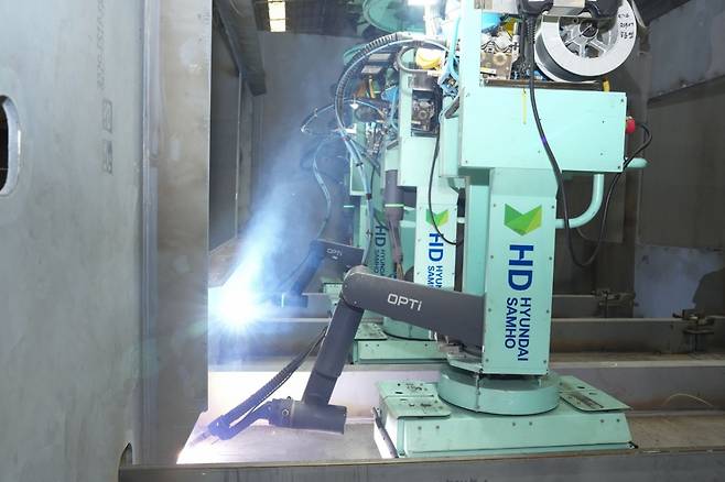 지난 14일 전남 영암에 위치한 HD현대삼호 조선소 판넬공장에서 용접로봇이 배의 중간부분에 들어가는 철판을 용접하고 있다./사진제공=HD현대