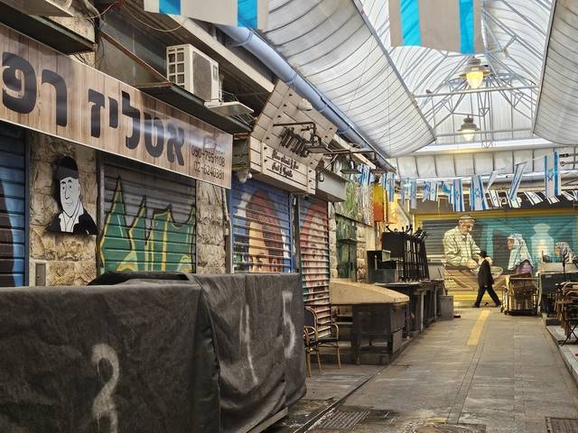 문 닫은 가게들 18일 이스라엘 예루살렘에 위치한 전통시장 ‘마하네 예후다’에서 문을 닫은 가게들 사이로 유대교 전통복장을 입은 한 남성이 지나가고 있다. 이날 이스라엘군은 ‘기드온의 전차 작전’ 일환으로 가자지구 북부와 남부 전역에서 광범위한 지상 작전을 개시했다.