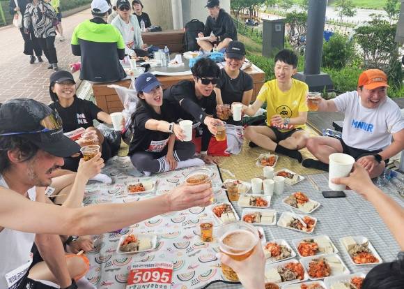 서울 금천구육상연맹회장배 금천사랑 마라톤대회 참가자들이 18일 안양천 다목적광장 일원에서 완주 후 수육과 막걸리 등을 즐기고 있다. 금천구 제공