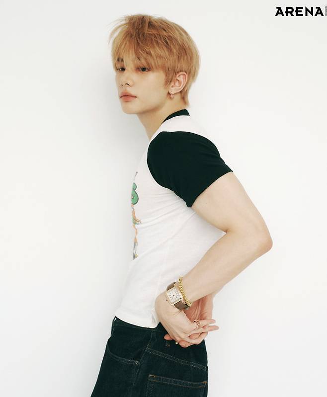 왼손에 착용한 (왼쪽부터) 핑크 골드 케이스의 산토스 뒤몽 워치 엑스트라 라지·옐로 골드 소재의 클래쉬 드 까르띠에 브레이슬릿 미디엄·검지의 핑크 골드 저스트 앵 끌루 링 클래식·소지의 핑크 골드 클래쉬 드 까르띠에 링 더블 로우·핑크 골드 소재의 클래쉬 드 까르띠에 싱글 이어링 라지 모두 까르띠에 제품. 그래픽 티셔츠·팬츠 모두 스타일리스트 소장품.