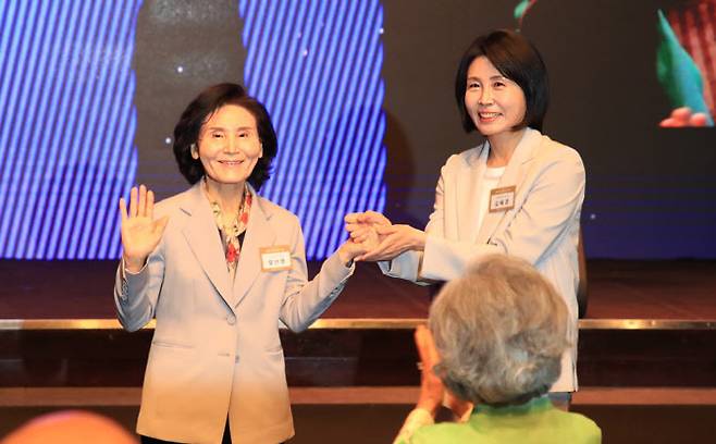 이재명 더불어민주당 대선 후보의 부인 김혜경 여사(오른쪽)와 김문수 국민의힘 대선후보의 부인 설난영(왼쪽) 여사가 12일 서울 중구 신라호텔에서 열린 중앙신도회 창립 70주년 기념식에서 손을 맞잡고 있다.(사진=조계종 제공)