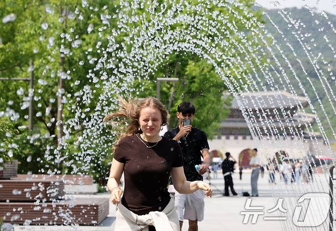 전국 대부분 지역 낮 기온이 25도 이상으로 올라 초여름 날씨를 보인 20일 서울 종로구 광화문광장 분수터널에서 외국인 관광객들이 더위를 식히고 있다. 2025.5.20/뉴스1 ⓒ News1 이동해 기자