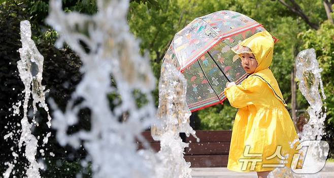 전국 대부분 지역 낮 기온이 25도 이상으로 올라 초여름 날씨를 보인 20일 서울 종로구 광화문광장 바닥분수에서 우의를 입은 한 어린이가 물놀이를 하며 더위를 식히고 있다. 2025.5.20/뉴스1 ⓒ News1 이동해 기자
