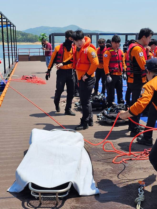 지난 19일 오전 11시쯤 경북 안동시 성곡동 안동댐 선착장 인근에서 경북소방본부 119구조대원들이 수색작업을 통해 인양한 시신을 수습하고 있다. 인양된 시신은 바지와 셔츠를 착용했고 머리와 발목 등 신체 일부가 훼손됐지만 대체로 온전한 상태였다. /권광순 기자