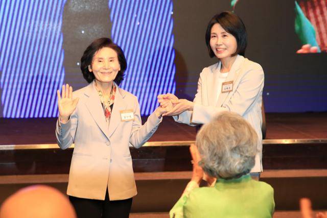 이재명 더불어민주당 대통령 후보의 부인 김혜경(오른쪽)씨와 김문수 국민의힘 대통령 후보의 부인 설난영씨가 12일 서울 중구 신라호텔에서 열린 중앙신도회 창립 70주년 기념식에 참석해 손을 잡고 있다. 뉴스1
