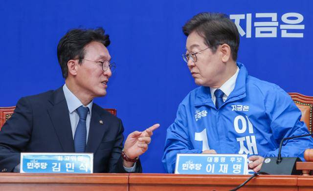 이재명 더불어민주당 대선 후보가 28일 서울 여의도 국회에서 열린 최고위원회의에 참석해 김민석 최고위원과 대화하고 있다. 뉴스1