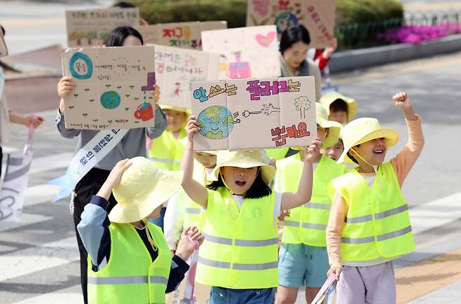 지난달 광주 북구청어린이집 아이들과 구청 기후환경과 직원들이 일회용품 사용을 줄이자는 의미와 탄소중립 손팻말을 들고 지구 살리기 길거리 캠페인을 펼치고 있다. 광주 북구 제공