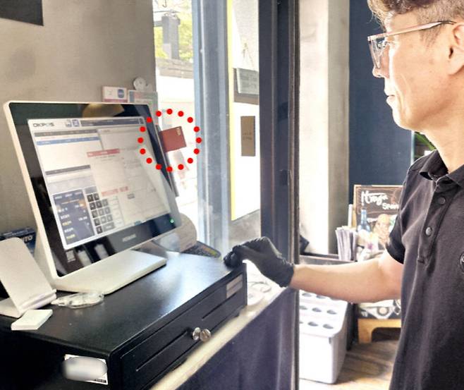 < ‘코인 체크카드’로 밥값 결제 > ﻿본지 기자가 지난 8일 서울 역삼동의 한 식당에서 13만원어치 음식을 먹고 스테이블 코인 카드로 99테더를 지불했다. 식당 주인이 스테이블 코인 카드(빨간 점선)를 받아 결제하고 있다.  /조미현 기자