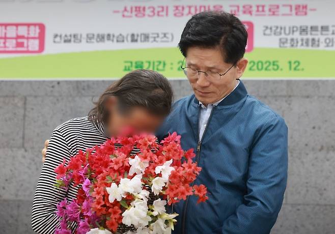 국민의힘 김문수 대선 후보가 4일 한센인 마을인 경기도 포천시 장자마을을 방문해 간담회에서 편지를 읽은 주민이 전달한 꽃다발을 받은 뒤 주민을 위로하고 있다. 사진=연합뉴스