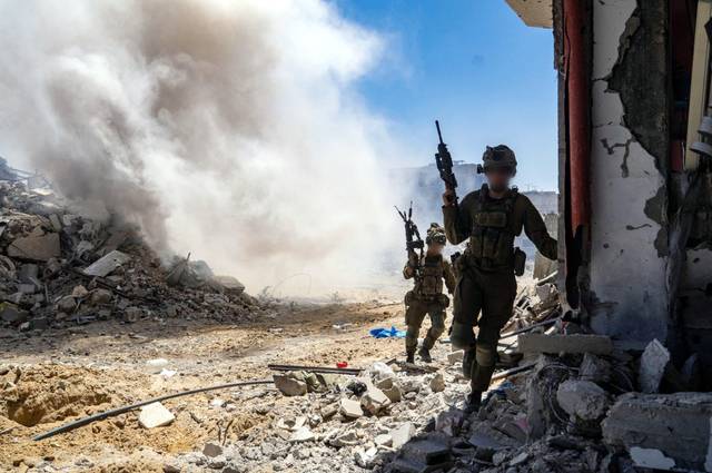 중무장한 이스라엘 군인들이 19일(현지시간) 포연이 피어오르는 가자지구에서 작전을 수행하고 있다. 신화연합뉴스