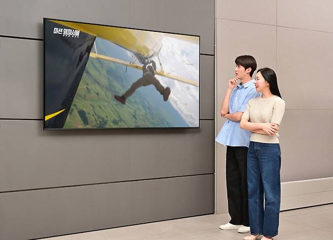 삼성전자 모델이 2025년형 QLED TV에서 상영되는 <미션 임파서블: 파이널 레코닝> 영상을 감상하고 있다. [사진 =삼성전자]