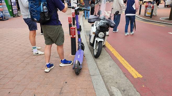 ‘킥보드 없는 거리’로 지정된 홍대레드로드에 주차된 킥보드와 오토바이.  안병준 기자