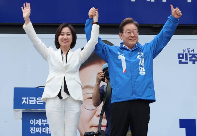 이재명 더불어민주당 대선 후보가 19일 서울 영등포구 타임스퀘어에서 열린 유세에서 허은아 전 개혁신당 대표와 함께 손을 잡고 지지를 호소하고 있다.