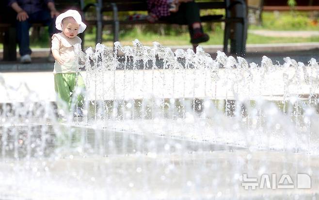 [대구=뉴시스] 이무열 기자 = 대구 낮 최고기온이 33도까지 오르며 무더운 날씨를 보인 20일 대구 서구 평리공원 바닥분수에서 아기가 물놀이를 하고 있다. 2025.05.20. lmy@newsis.com