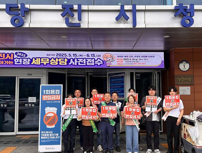 [당진=뉴시스] 당진시 자원순환과 공무원이 지난 16일 당진시청 앞에서 '1회용컵 반입금지' 손팻말을 들고 1회용품 제로청사 캠페인을 벌이고 있다. (사진=당진시 제공) 2025.05.20. photo@newsis.com  *재판매 및 DB 금지
