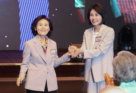 김문수 국민의힘 대선 후보의 배우자 설난영(왼쪽)씨와 이재명 더불어민주당 대선 후보의 배우자 김혜경씨가 12일 서울 중구 신라호텔에서 열린 대한불교조계종 중앙신도회 창립 70주년 기념식에서 손을 맞잡고 있다. 2025.5.12 연합뉴스