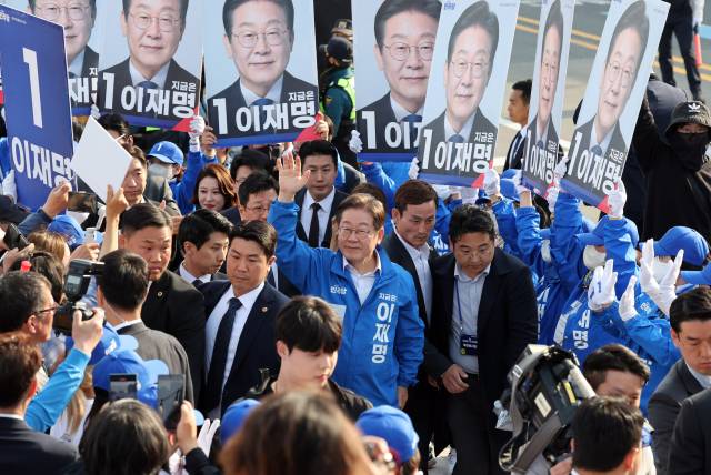 이재명 더불어민주당 대선 후보의 선거운동원들이 14일 경남 통영 강구안 문화마당에서 피켓을 높이 들어 이 후보를 에워싼 채 이동하고 있다. 통영=오승현 기자 2025.05.14