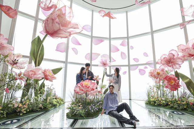 서울스카이 모델들이 20일 서울 송파구 롯데월드타워 전망대 서울스카이 118층 스카이데크에 핑크빛 대형 꽃들로 꾸며진 '유니버스 플라워' 앞에서 '블루밍 유니버스' 기획을 알리고 있다. 오승현 기자 2025.05.20