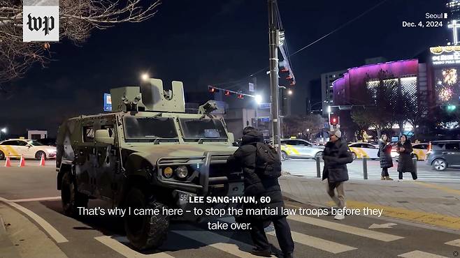 2024년 12월4일 새벽 서울 여의도 국회 인근에서 김동현씨가 몸으로 군용차를 막고 있다. ⓒ워싱턴포스트 화면 갈무리