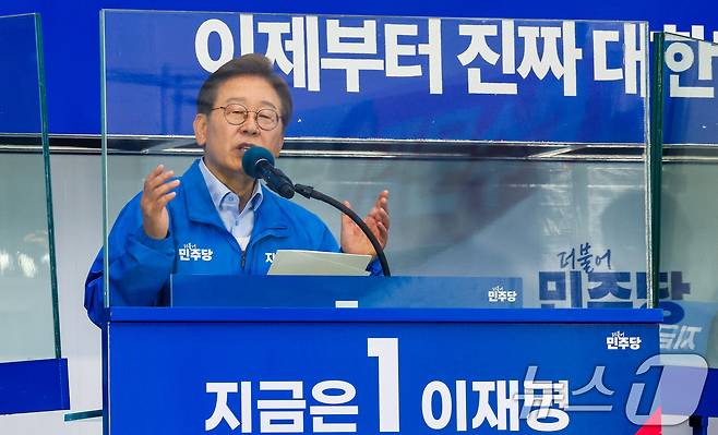 이재명 더불어민주당 대통령 후보가 사흘째 수도권 표심잡기에 나선 21일 오후 자신의 지역구인 인천 계양구 계양역을 찾아 유세하는 가운데 이 후보의 방탄 유리에 김문수 국민의힘 후보 현수막이 반사되어 비치고 있다. 2025.5.21/뉴스1 ⓒ News1 안은나 기자