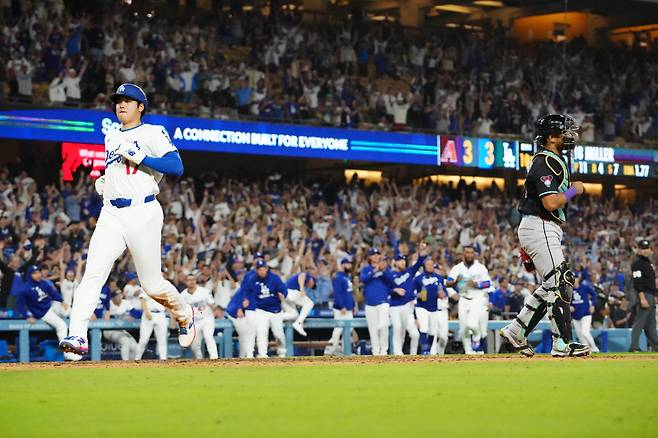 오타니 쇼헤이가 연장 10회말 맥스 먼시의 중견수 희생플라이 때 3루에서 홈으로 뛰어들고 있다. Imagn Images연합뉴스