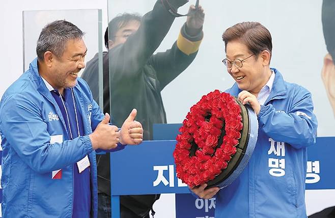 장미꽃 투표 기호 든 이재명 - 이재명 더불어민주당 대선 후보가 20일 경기 고양시 일산문화공원에서 장미꽃으로 만든 투표 기호를 들며 웃고 있다. 왼쪽은 이 후보 지원 유세에 나선 배우 이원종씨. 이 후보는 이날 “일산대교 통행료 무료화를 추진하겠다”고 했다. /연합뉴스