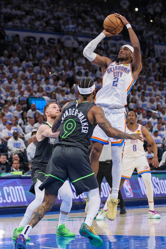 오클라호마시티 썬더의 샤이 길저스 알렉산더가 21일 열린 NBA 서부 결승 1차전에서 미네소타 팀버울브스의 니켈 알렉산더 워커의 수비를 피해 점프슛을 시도하고 있다. 똑같이 1998년생인 두 선수는 사촌이다. 길저스 알렉산더의 아버지와 알렉산더 워커의 어머니가 남매다. /AP 연합뉴스