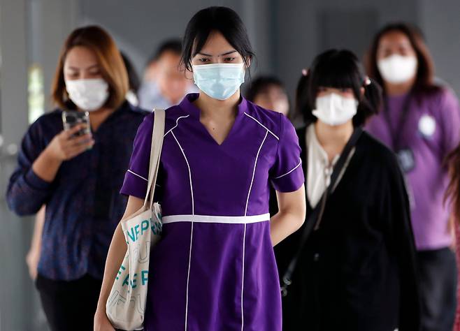 지난 20일 태국 수도 방콕에서 마스크를 쓴 시민들이 거리를 걷고 있다. 태국은 지난주 코로나 환자가 3만3000여 명으로 전 주의 2배 이상으로 늘었다. 최근 중국, 홍콩, 대만에서도 코로나 환자가 증가했다./EPA 연합뉴스
