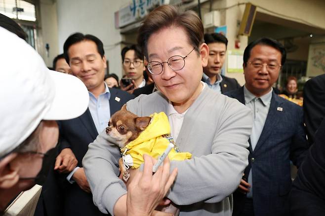 민심을 청취하는 ‘경청 투어’에 나선 이재명 더불어민주당 대선후보가 11일 전남 강진군 강진오감통시장에서 한 주민의 강아지를 안아보고 있다. 2025.05.11 강진=뉴시스