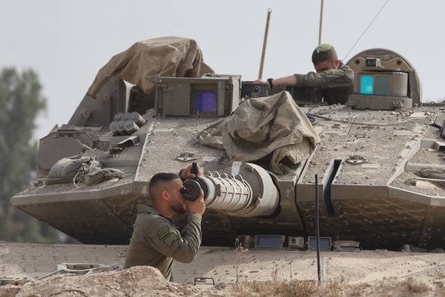 가자지구 접경지대에서 이스라엘 군인이 목표물을 향해 탱크 포신을 맞추고 있습니다. EPA 연합뉴스