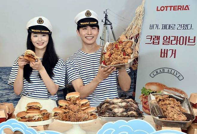21일 서울 롯데리아 동대문역사문화공원역점에서 모델들이 롯데리아 신제품 '크랩 얼라이브 버거'를 홍보하고 있다. /롯데리아 제공