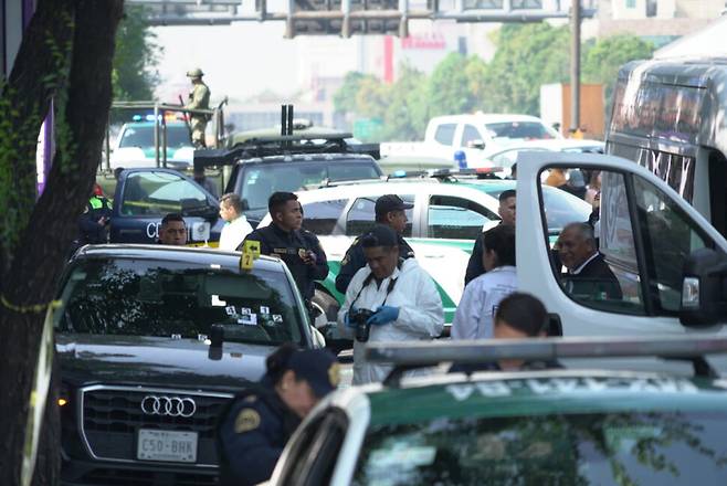 멕시코시티 시장의 비서와 정책자문관이 총격을 받아 사망한 현장에서 경찰관들이 조사를 벌이고 있다. 왼쪽 검은 아우디 SUV 차량이 총격을 받은 차량이다. 사진 엘파이스