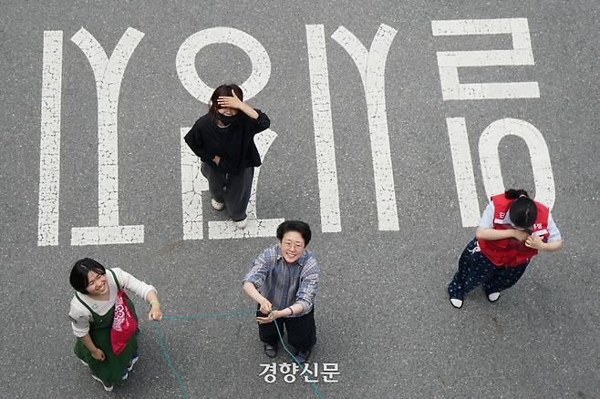 ‘말벌동지’들이 박정혜 금속노조 한국옵티칼하이테크지회 수석부지회장이 농성 중인 구미공장 옥상에 식사 등을 전달하는 도르래줄을 잡고 있다. 임아영 기자