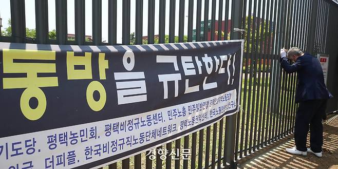 고(故) 이선호 씨의 아버지  이재훈씨가 2021년 6월19일 오전 경기 평택시 안중백병원 장례식장에서 열린 이씨의 시민장(葬)을 마친 뒤 아들과 함께 일하던 평택항 (주)동방 사무실 앞 철문을 붙잡은 채 눈물을 흘리고 있다. 경향신문 자료사진