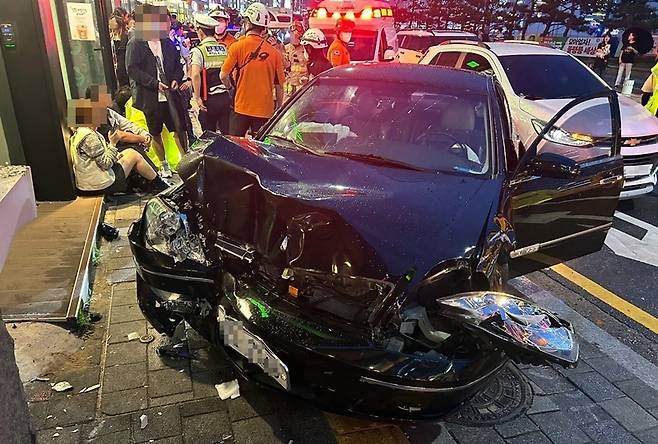 21일 오후 부산 수영구 광안해변로에서 승용차가 인도로 돌진해 보행자들을 다치게 한 사고 현장. 차량이 연석과 보행로 구조물을 들이받으며 보행자 5명이 부상을 입었다. 부산소방본부 제공