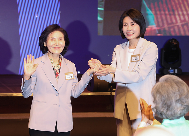 김문수 국민의힘 대선 후보의 부인 설난영씨(왼쪽)와 이재명 더불어민주당 대선 후보의 부인 김혜경씨가 12일 서울 중구 신라호텔에서 열린 조계종 중앙신도회 창립 70주년 기념식에서 인사한 뒤 손을 잡고 사진 촬영을 하고 있다. [사진출처=연합뉴스]