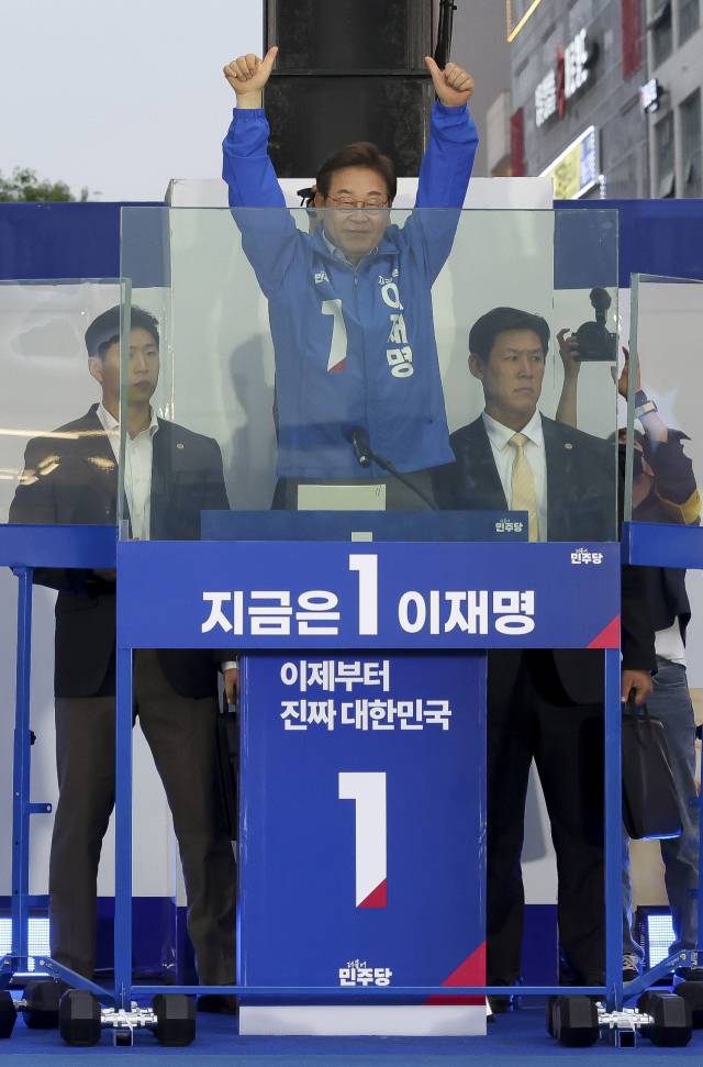 이재명 더불어민주당 대선 후보가 제21대 대통령선거 재외국민투표가 시작된 20일 경기 김포시 구래역 문화의 거리에서 유세를 하며 사다리에 올라 방탄유리 위로 얼굴을 내밀어 뒷열에 자리하고 있는 시민들에게 인사하고 있다.김포=오승현 기자 2025.05.20