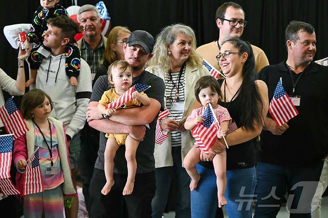 지난 12일(현지시간) 미국 워싱턴DC 인근 덜레스 국제공항에 도착한 남아프리카 공화국 백인 난민 신청자들이 미국 정부 관계자의 환영사를 듣기 위해 대기하고 있다. 2025.05.13 ⓒ AFP=뉴스1 ⓒ News1 류정민 특파원