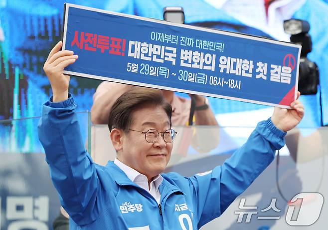 이재명 더불어민주당 대통령 후보가 22일 오후 경남 양산시 양산워터파크공원에서 열린 유세에서 '사전투표! 대한민국 변화의 위대한 첫 걸음'이라고 적힌 현수막을 들어보이고 있다. 2025.5.22/뉴스1 ⓒ News1 이재명 기자