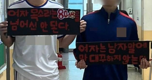 남학생들이 "여자 목소리는 80데시벨이 넘어선 안 된다" 등의 문구가 담긴 손팻말을 들고 있다. /온라인 커뮤니티