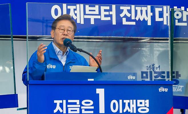 이재명 더불어민주당 대통령 후보가 사흘째 수도권 표심잡기에 나선 21일 오후 자신의 지역구인 인천 계양구 계양역을 찾아 유세하는 가운데 이 후보의 방탄 유리에 김문수 국민의힘 후보 현수막이 반사되어 비치고 있다. /뉴스1
