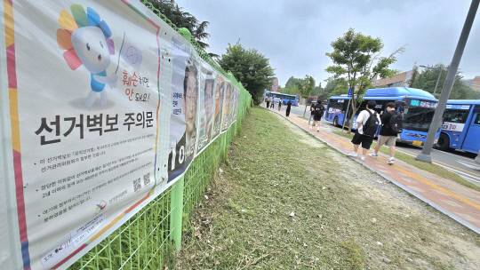 22일 목원대학교 정문 앞 제21대 대통령선거 후보들의 벽보가 붙여진 거리를 대학생들이 걸어가고 있다. 이성현 기자