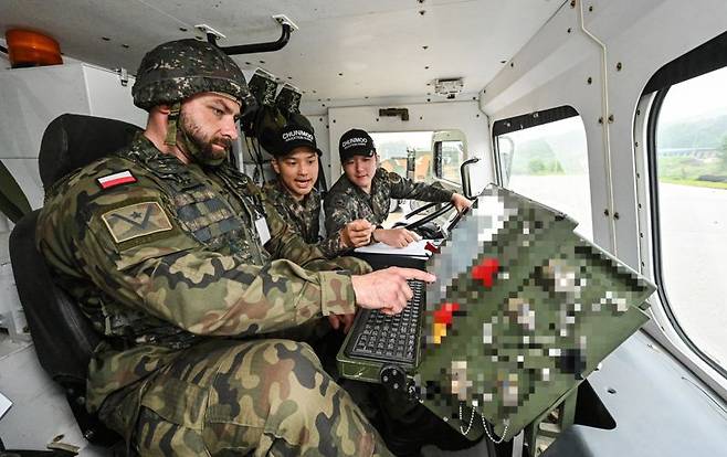 육군은 22일, 해외 주요 방산협력국 장병들을 대상으로 K-무기체계의 전술적 운용을 교육하는 '육군 국제과정' 현장 모습을 공개했다. 이번 훈련은 국제과정 최초로 천무 교육이 개설되었으며, 15일부터 2주간 폴란드 장병 16명이 교육훈련을 받고 있다. 사진은 폴란드군 교육생들이 천무의 조작 및 기동을 실습하고 있다. 육군 제공
