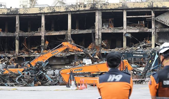 지난 20일 오전 광주 광산구 송정동의 금호타이어 공장 화재 현장에서 소방 관계자들이 건물 해체 작업을 지켜보고 있다. 연합뉴스