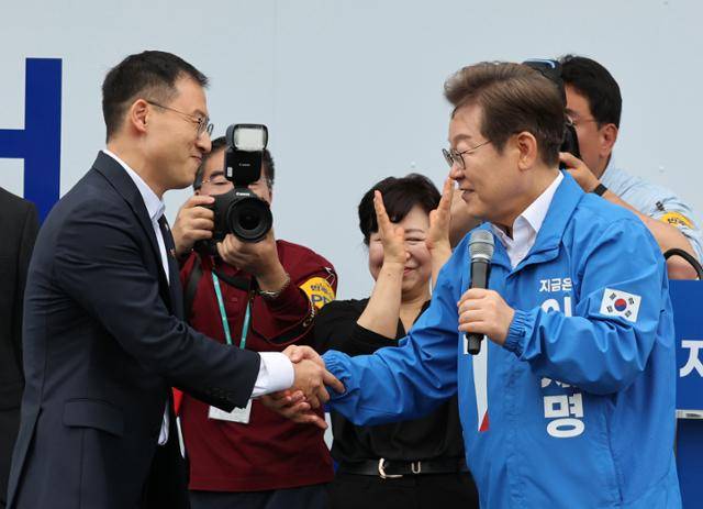 이재명 더불어민주당 대선 후보가 16일 전북 익산역 동부광장 유세에서 최근 국민의힘을 탈당한 김상욱 의원과 악수하고 있다. 익산=고영권 기자
