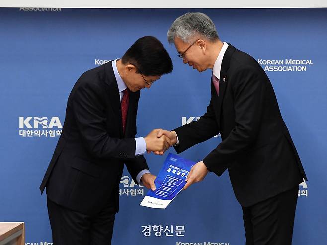 김문수 국민의힘 대선 후보가 22일 오후 서울 용산구 대한의사협회에 열린 의협 회장단과의 간담회에 참석해 김택우 의사협회장으로부터 정책제안서를 받고 있다. 한수빈 기자