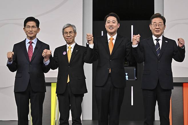 From left: Four presidential candidates, Kim Moon-soo, Kwon Young-kook, Lee Jun-seok and Lee Jae-myung, pose for a photo ahead of their first televised debate on Sunday. (Pool photo)